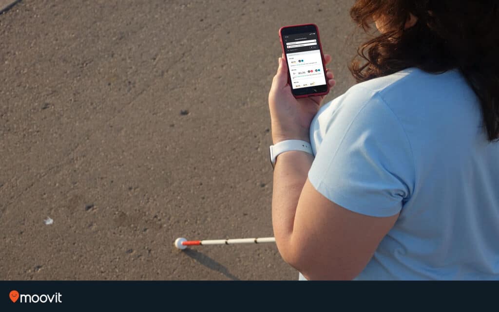 Pessoal usando o aplicativo Moovit e um bastão de orientação